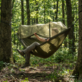 Relaxing in the packable camping hammock with mosquito net